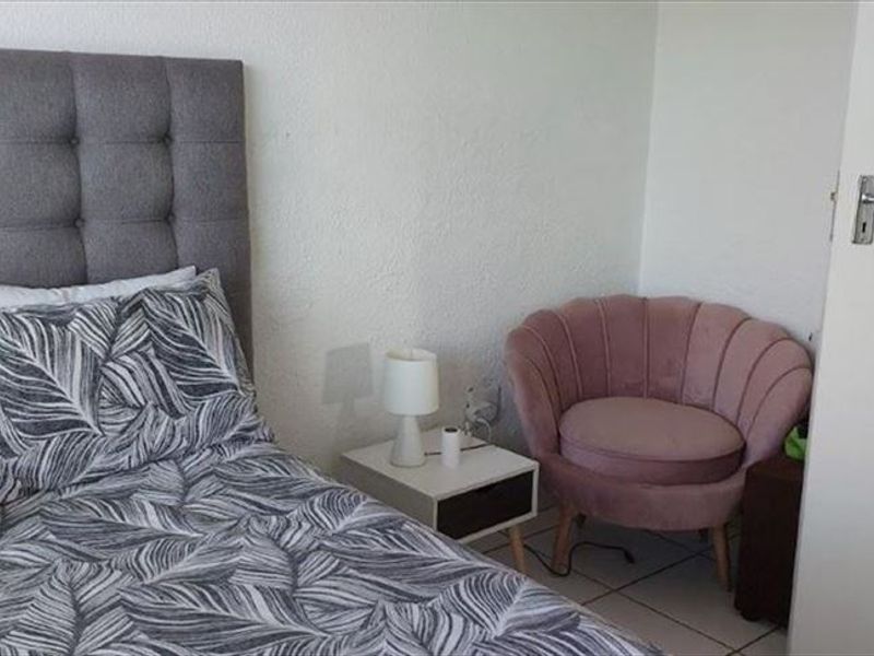 A bedroom featuring tiled flooring and a standard internal door, providing a functional and neutral living space.
