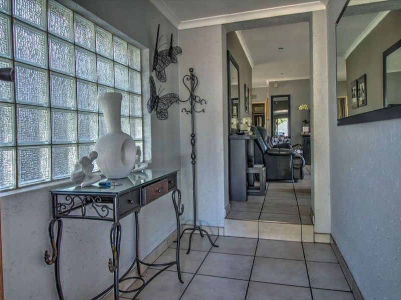 Entrance hall featuring tiled flooring and a distinctive glass block window, leading into the main living area of the home.