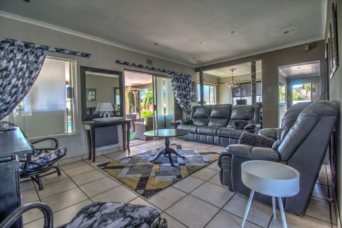 Spacious living room featuring tiled flooring, recessed lighting, and sliding glass doors providing access to the outdoor patio area.