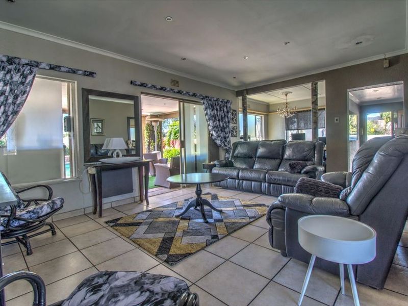 Spacious living room featuring tiled flooring, recessed lighting, and sliding glass doors providing access to the outdoor patio area.