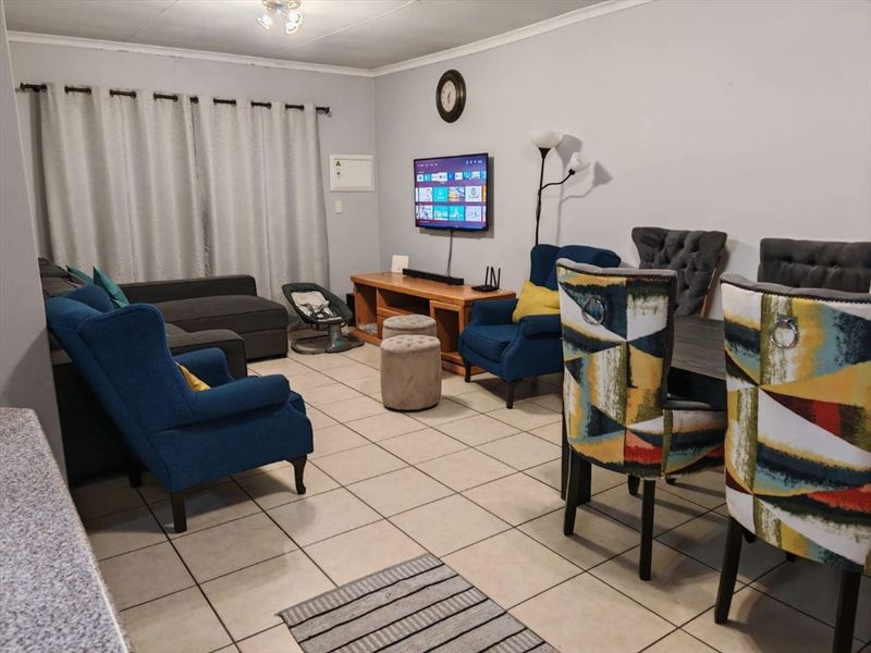 Open plan living and dining area featuring tiled flooring and neutral wall finishes, providing a functional space for daily living.