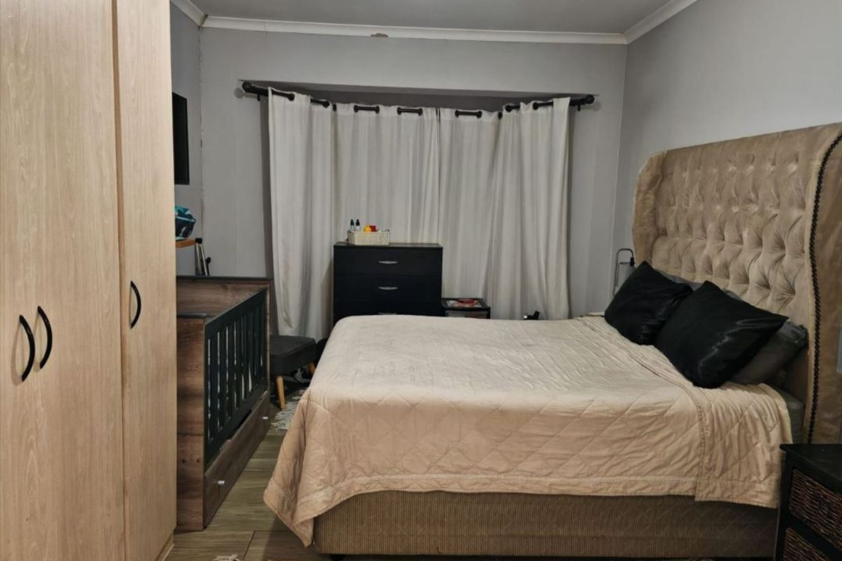 A functional bedroom featuring a built-in wardrobe and neutral wall finishes, providing a comfortable and practical sleeping space.