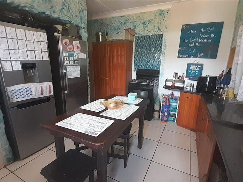 A functional kitchen featuring tiled flooring, built-in cabinetry, and a gas stove, currently requiring cosmetic updates to the wall finishes.