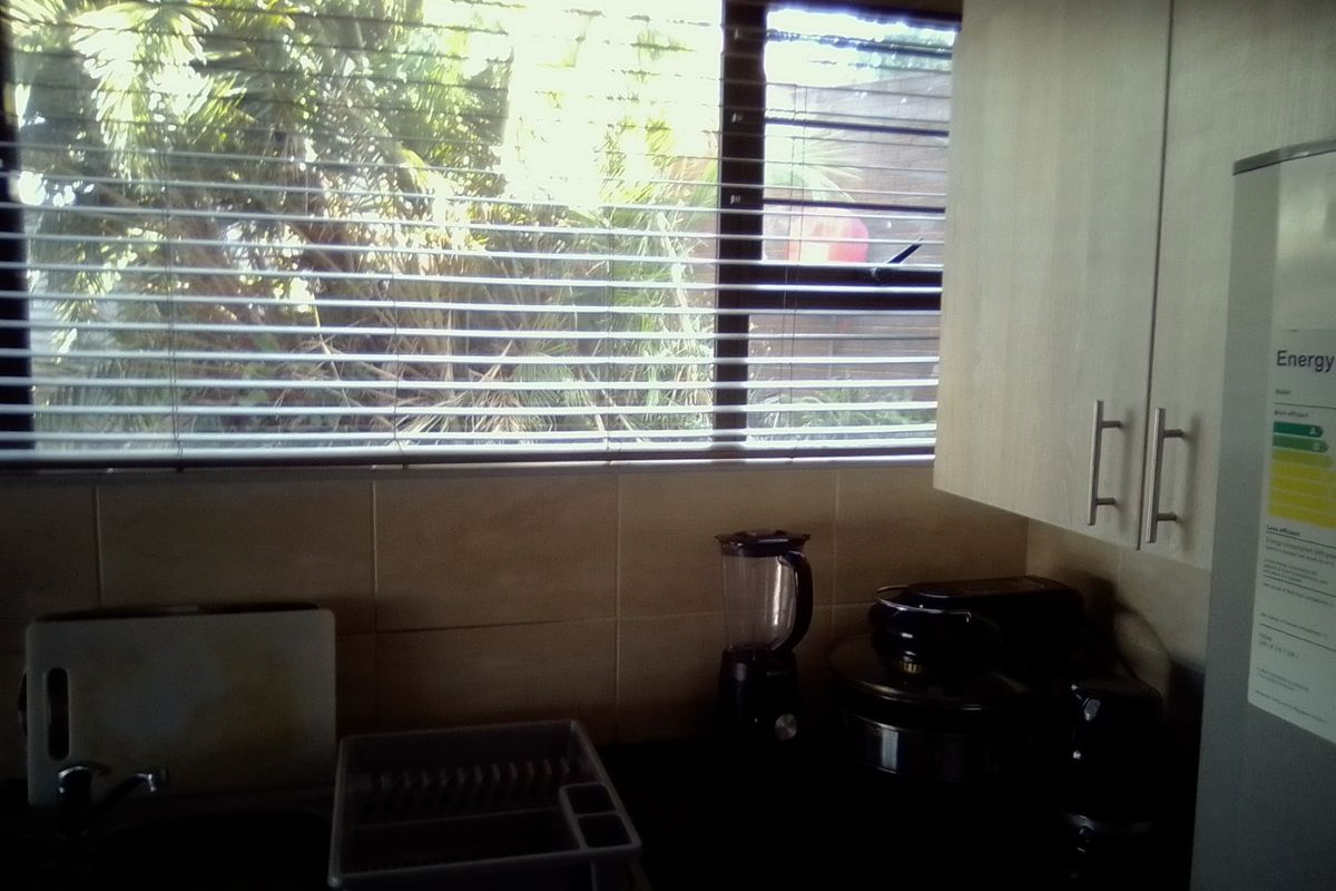 A functional kitchen area featuring built-in cabinetry, a tiled backsplash, and a window overlooking the exterior.