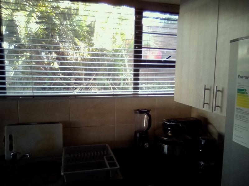 A functional kitchen area featuring built-in cabinetry, a tiled backsplash, and a window overlooking the exterior.
