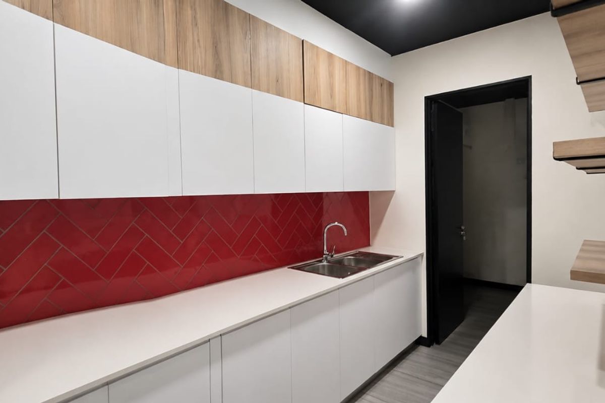 Modern kitchen featuring white and wood-tone cabinetry, a striking red herringbone splashback, double sink, and floating shelving.