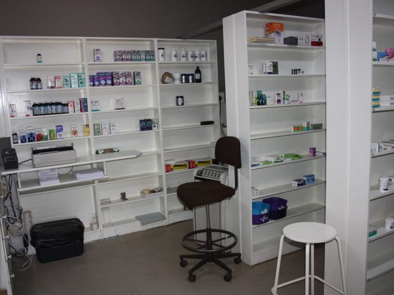 A functional commercial utility or storage space featuring extensive built-in white shelving units for organized inventory management.