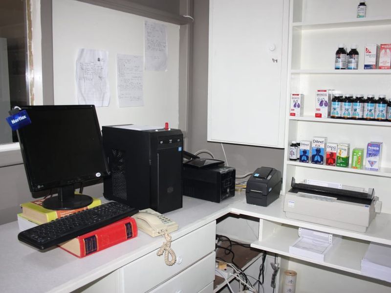 A functional commercial office workspace featuring built-in cabinetry and shelving units for storage and administrative tasks.