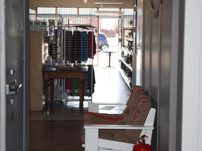 Entryway leading into a commercial retail space with laminate flooring and a clear view through the front glass storefront.