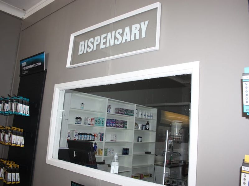 A commercial dispensary area featuring a service window and built-in shelving for organized storage of pharmaceutical products.