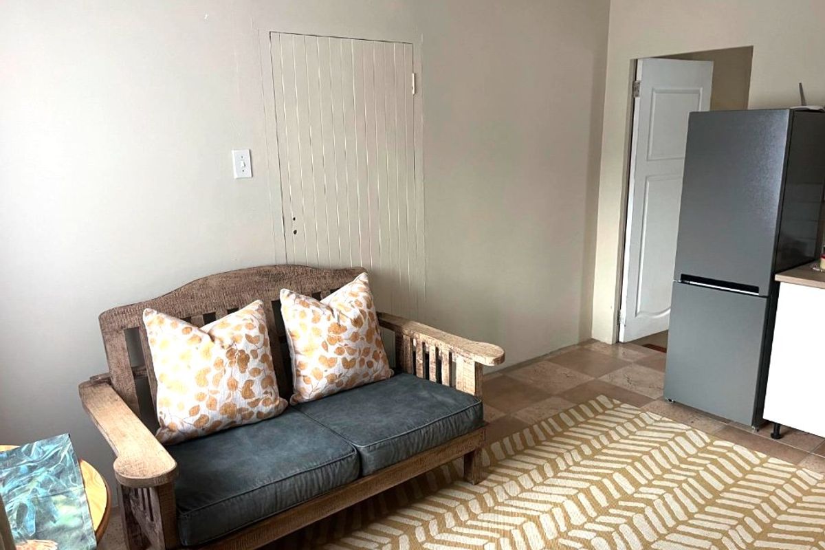 A living area featuring tiled flooring and a built-in wall panel feature, providing a neutral base for interior design.
