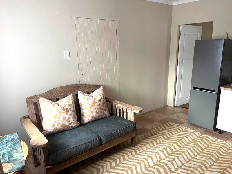 A living area featuring tiled flooring and a built-in wall panel feature, providing a neutral base for interior design.