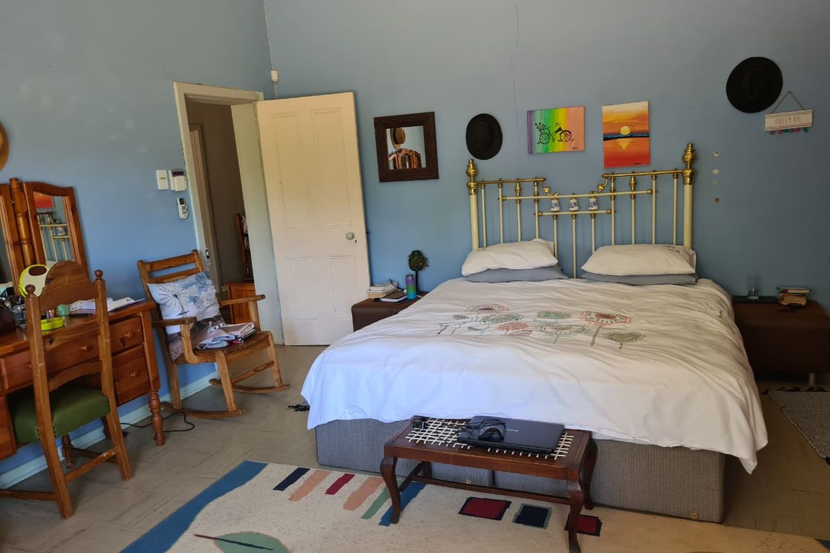 A bedroom featuring blue walls with a visible vertical crack, standard door, and skirting boards.
