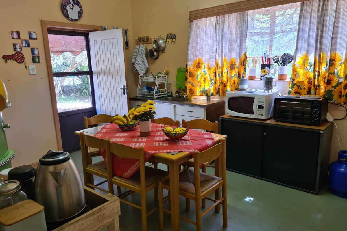 A functional kitchen area featuring built-in cabinetry, a sink, and direct access to the exterior, offering potential for modernization and layout optimization.