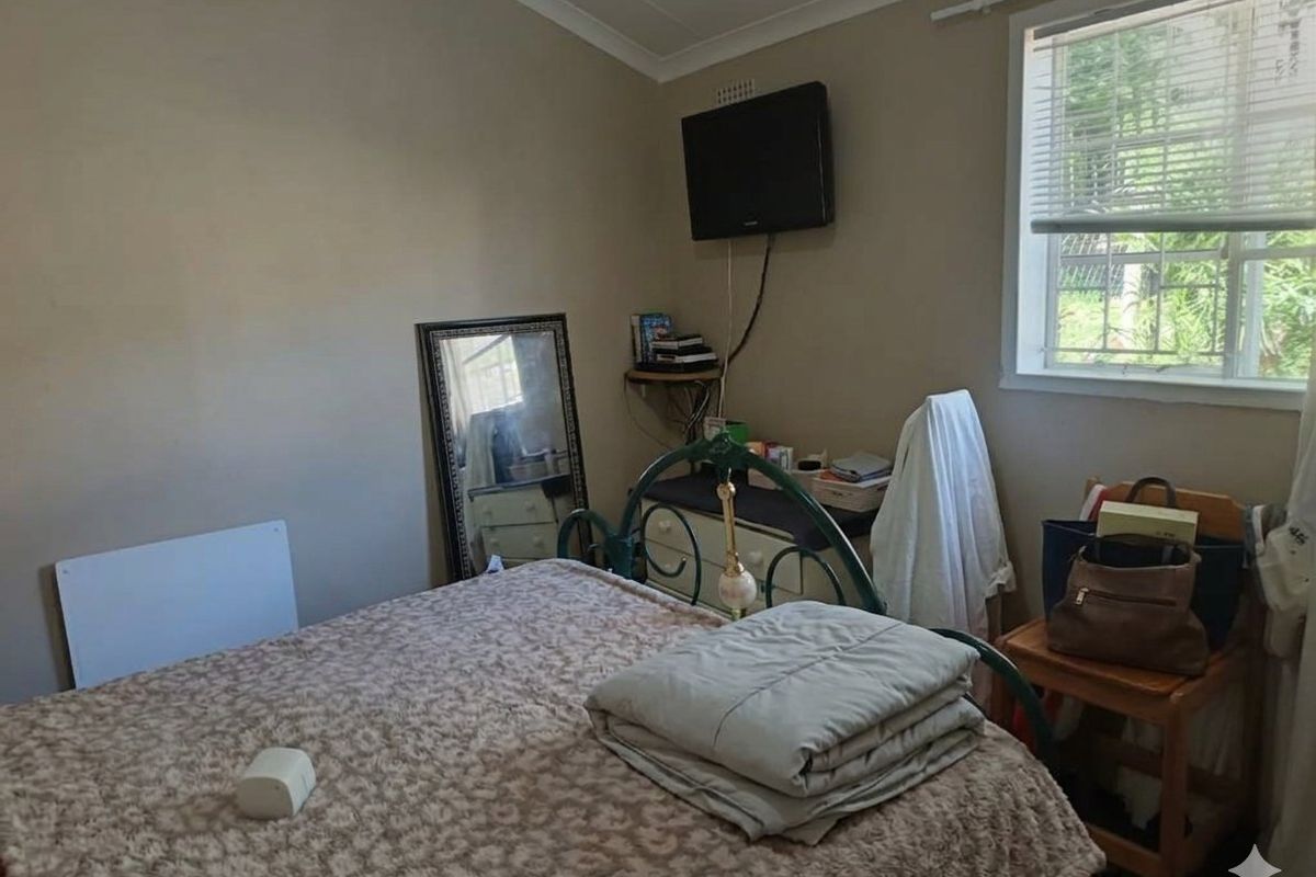 A standard bedroom featuring neutral wall paint, a window with fitted blinds, and coving detail.