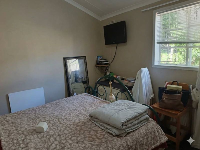 A standard bedroom featuring neutral wall paint, a window with fitted blinds, and coving detail.