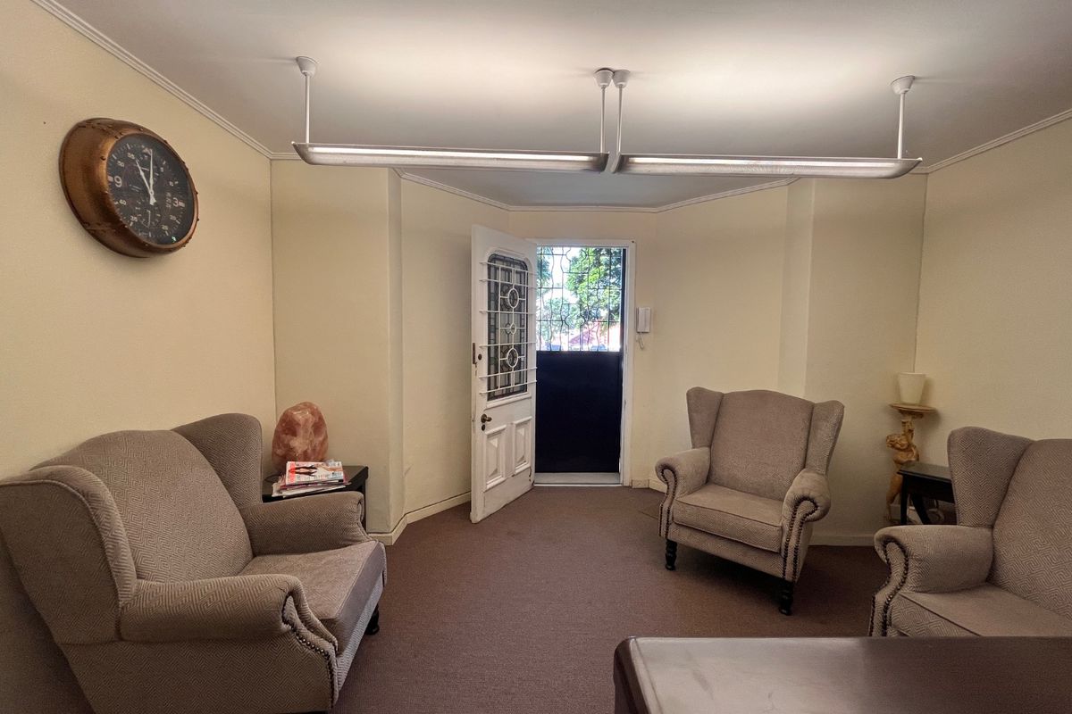 A functional entry area featuring a security gate, intercom system, and overhead fluorescent lighting, providing a practical access point for the commercial space.