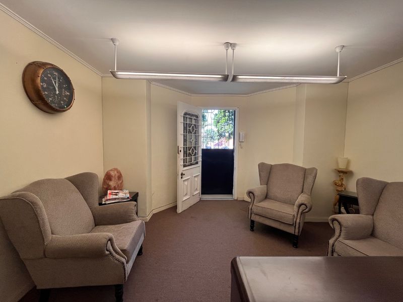 A functional entry area featuring a security gate, intercom system, and overhead fluorescent lighting, providing a practical access point for the commercial space.
