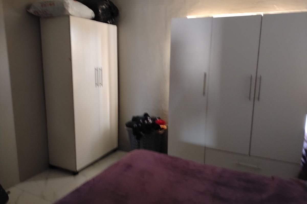 A bedroom featuring tiled flooring and built-in storage cabinetry.