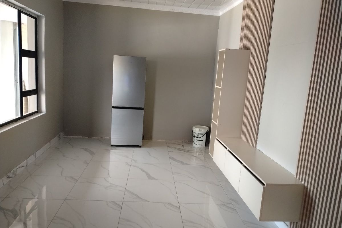 A bright, modern living area featuring large marble-look floor tiles, a decorative slatted timber wall feature, and sleek built-in floating cabinetry.