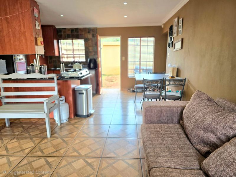 Open-plan living and kitchen area featuring tiled flooring, recessed lighting, and direct access to the rear exterior.