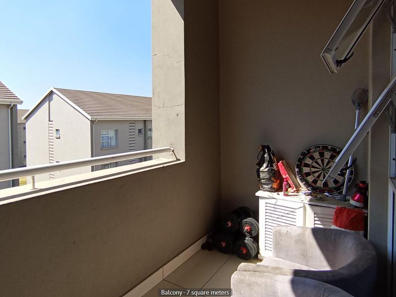 A private balcony featuring tiled flooring and a metal balustrade, offering an outdoor space accessible from the apartment.