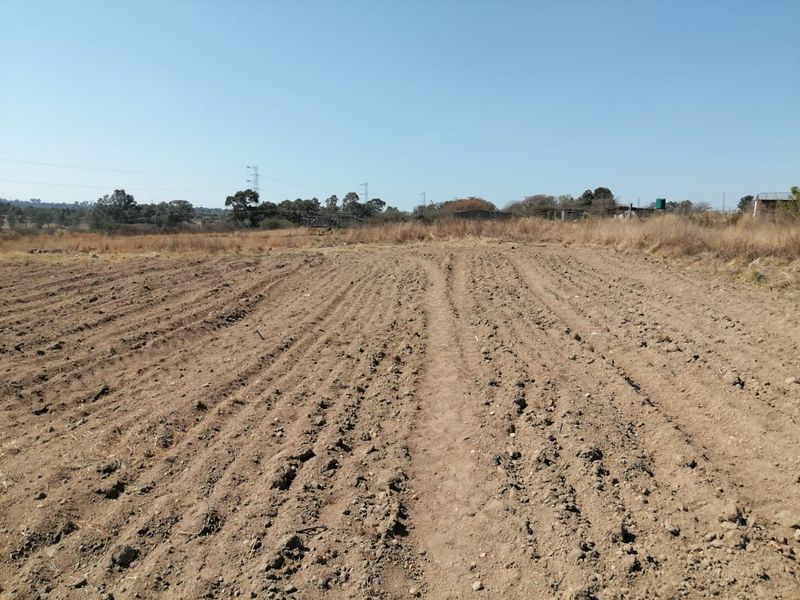 A view of a vacant residential plot featuring cleared, unimproved soil and open land.