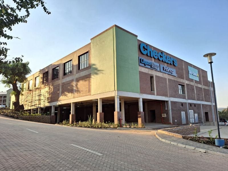 Exterior view of a modern brick commercial building featuring covered parking and prominent retail signage.