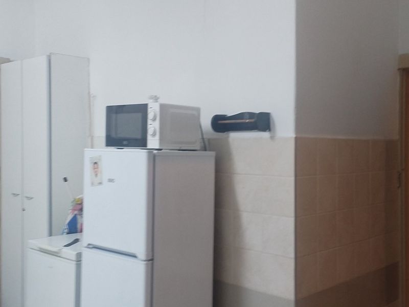 A functional kitchen area featuring built-in cabinetry and tiled splashback, offering a practical layout for daily use.