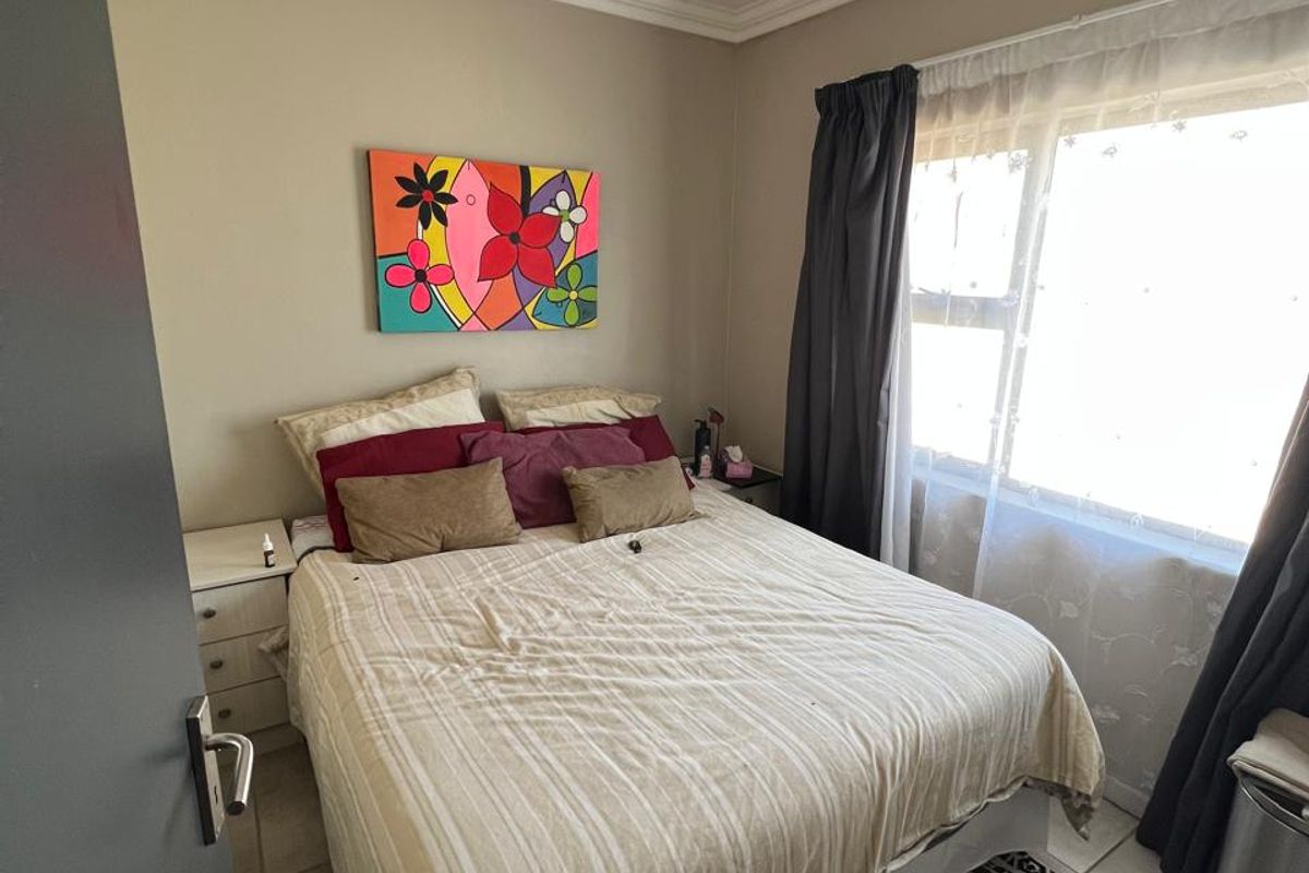 A cozy bedroom featuring tiled flooring and a classic tongue and groove ceiling, providing a functional and comfortable living space.