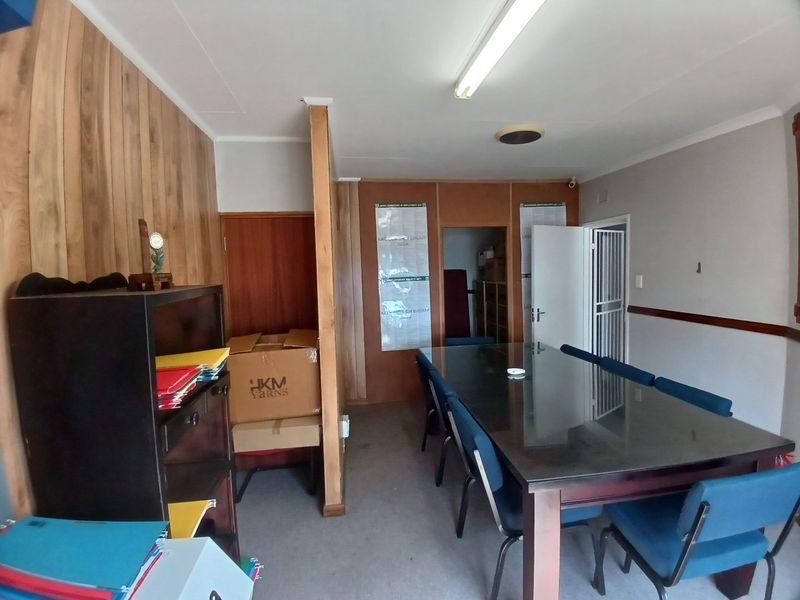 A functional office space featuring wood paneling, fluorescent lighting, and carpet flooring, suitable for a professional work environment.