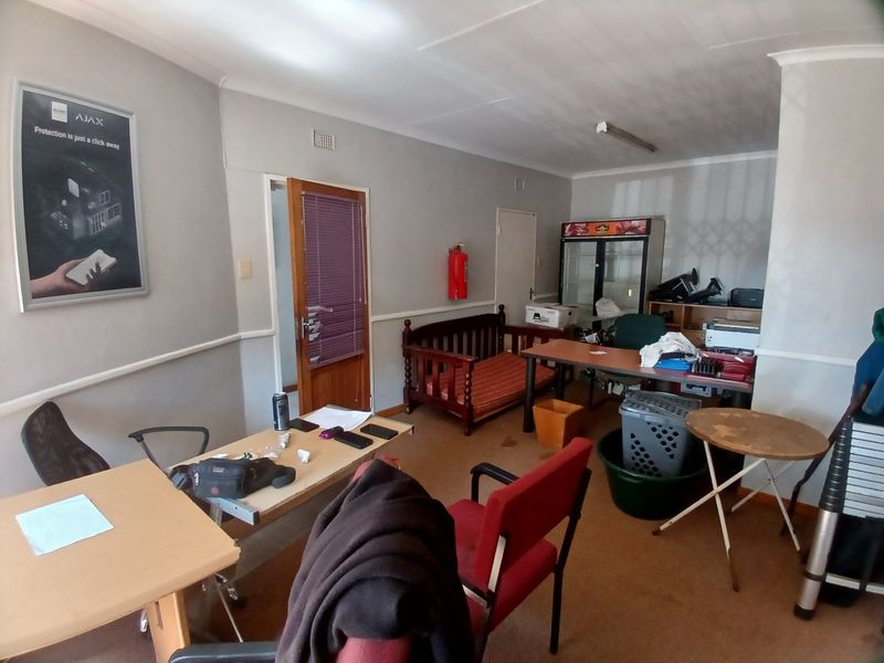 A commercial office space featuring neutral walls, coving, and carpeted flooring, currently utilized as a workspace.