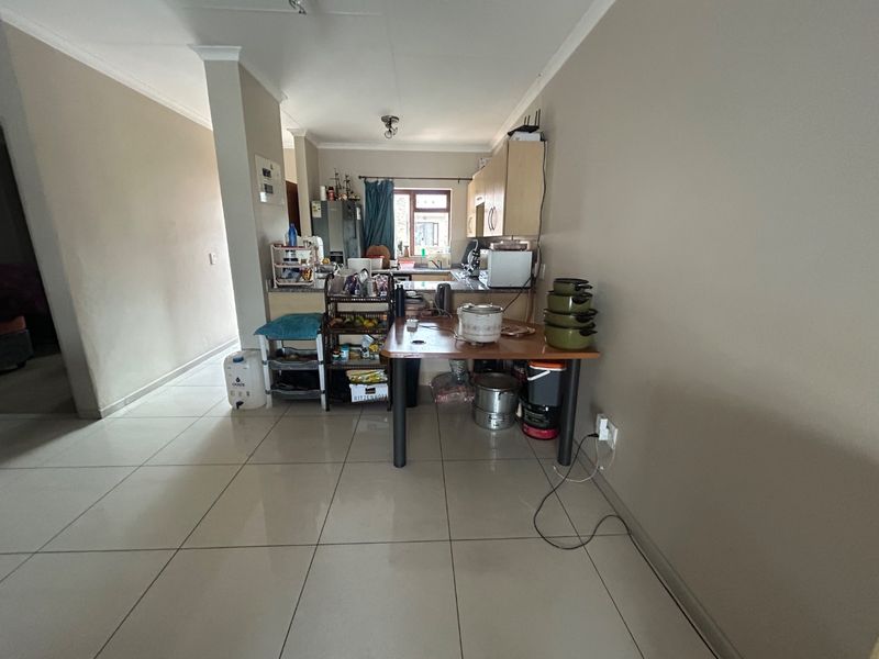 Open plan living and kitchen area featuring tiled flooring and functional cabinetry, providing a versatile space for daily living and meal preparation.