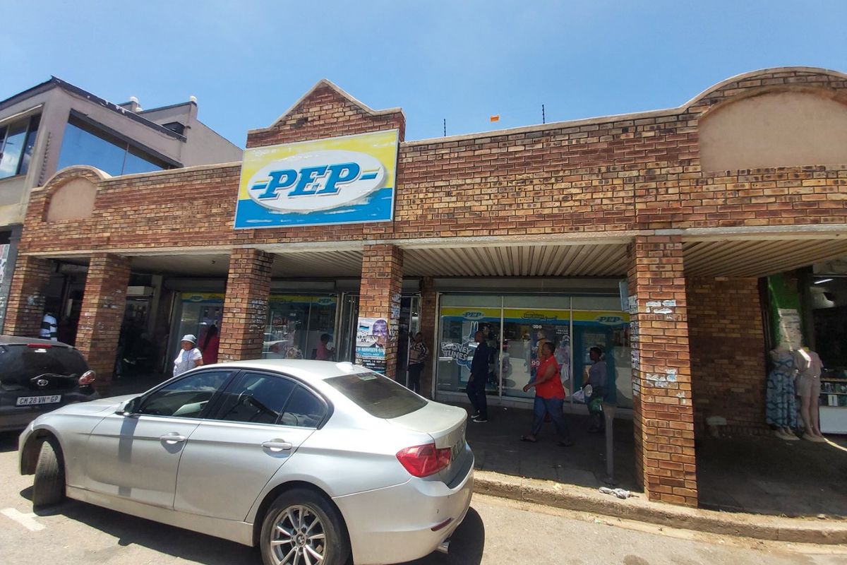 Commercial storefront featuring a face brick facade, brick pillars, and large glass display windows, providing high visibility for retail operations.