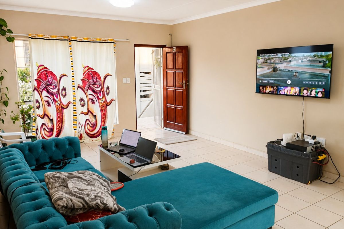 A functional living room featuring tiled flooring, a ceiling light, and a wooden entrance door, providing a neutral base for interior design updates.