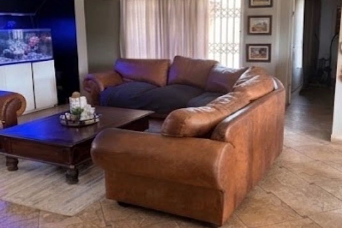 Spacious living room featuring tiled flooring, recessed lighting, and a built-in alcove area, providing a comfortable and functional family space.