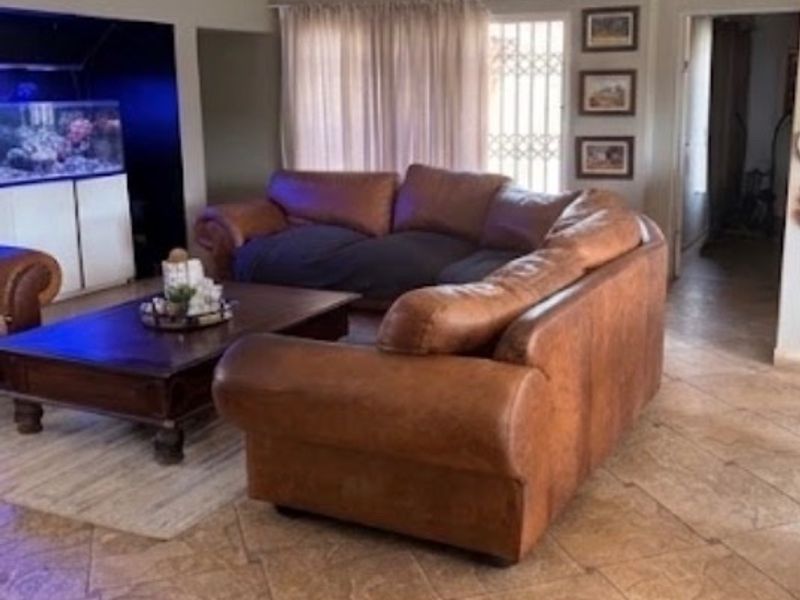 Spacious living room featuring tiled flooring, recessed lighting, and a built-in alcove area, providing a comfortable and functional family space.