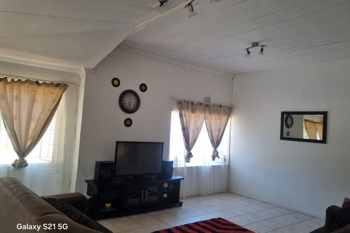 A living room featuring tiled flooring and a timber ceiling, currently showing visible signs of ceiling damage requiring repair.