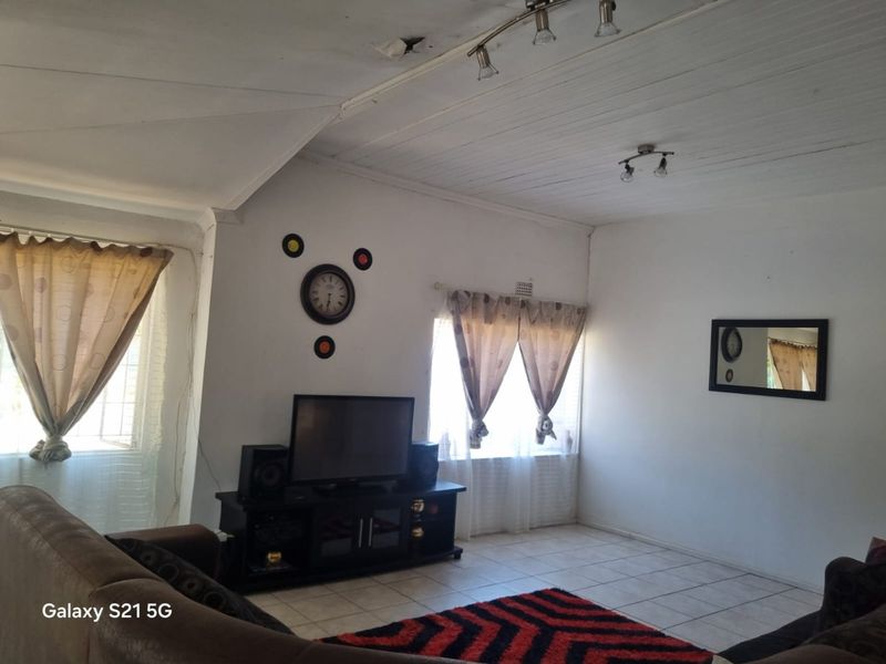 A living room featuring tiled flooring and a timber ceiling, currently showing visible signs of ceiling damage requiring repair.