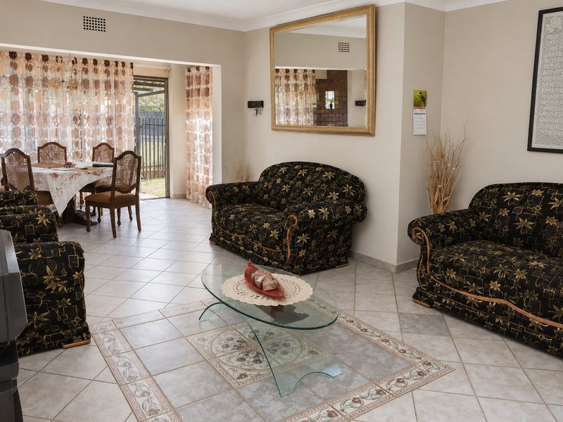 Open plan living and dining area featuring ceramic tiled flooring with decorative inlay and direct access to the outdoor space via sliding glass doors.
