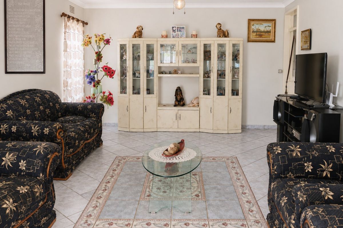 A living room featuring ceramic floor tiles, a ceiling fan, and built-in display cabinetry.