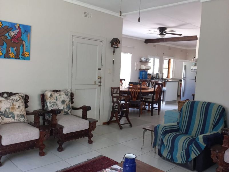 Open plan living and dining area featuring tiled floors, ceiling fans, and a seamless transition into the kitchen space.