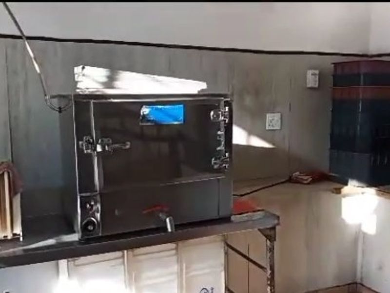 A functional commercial scullery or prep area featuring a stainless steel industrial oven and built-in work surfaces for food preparation.