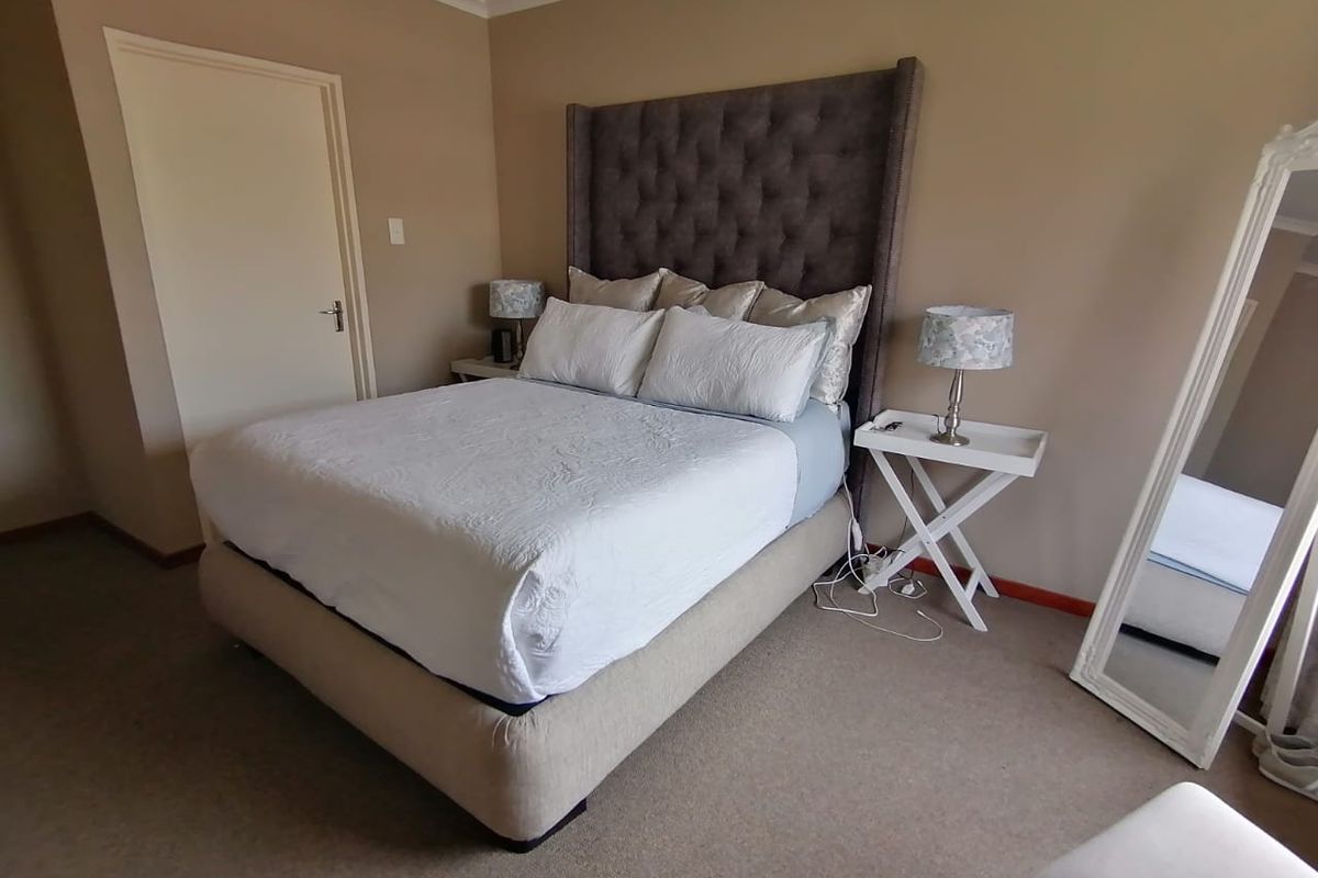 A carpeted bedroom featuring neutral wall tones and a coved ceiling, providing a comfortable and functional sleeping space.