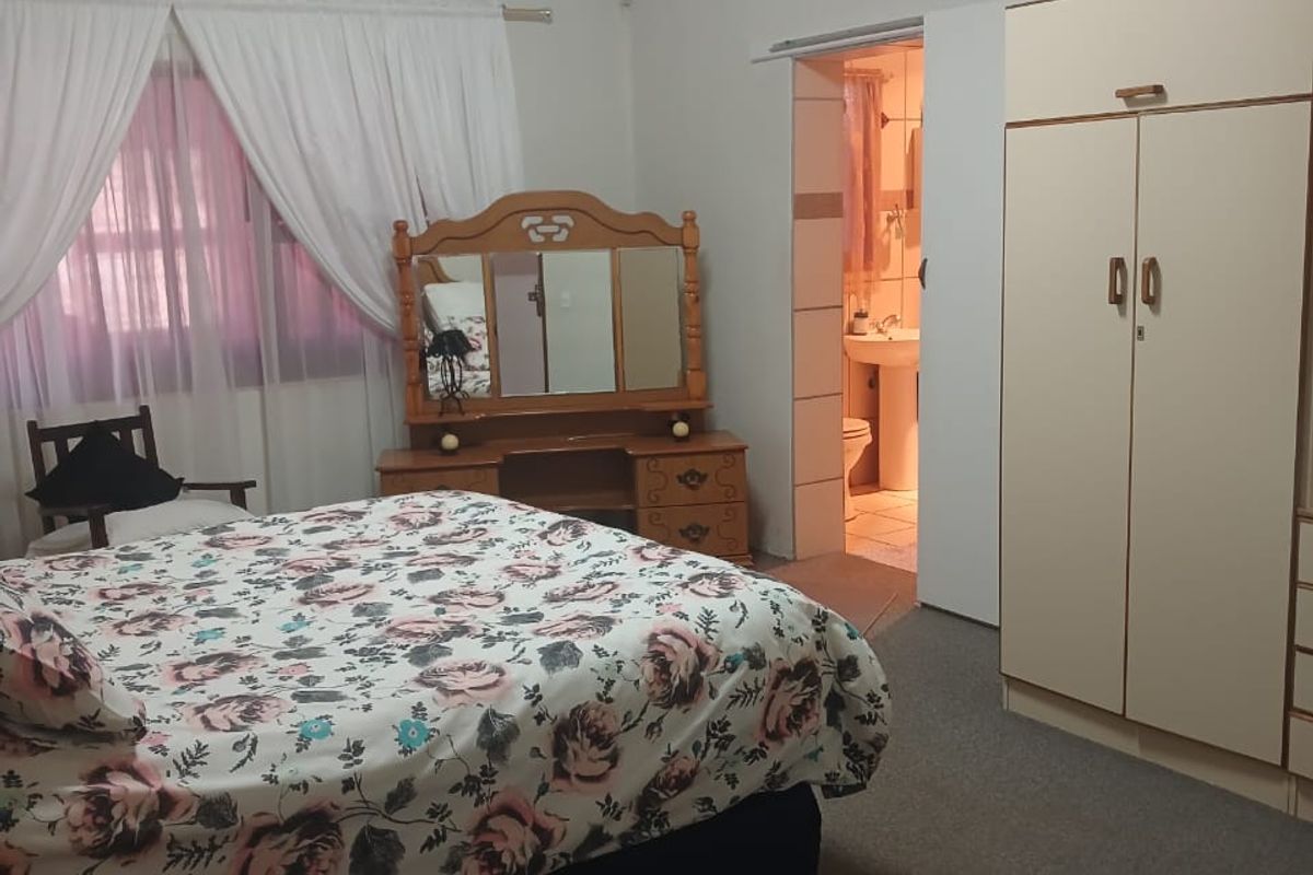 A bedroom featuring carpet flooring, a built-in wardrobe, and direct access to an en-suite bathroom.