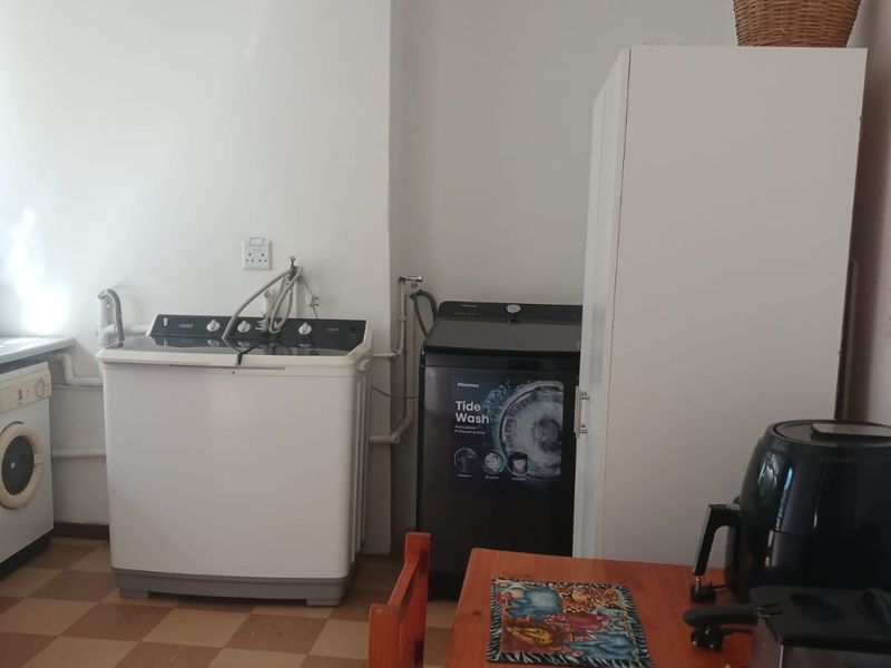 A functional laundry area featuring tiled flooring and dedicated plumbing connections for washing machines.