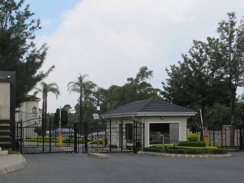 The secure entrance to the apartment complex features a gated access point, a dedicated guard house, and perimeter electric fencing.