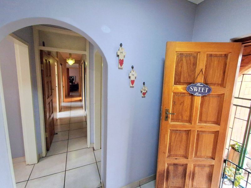 A functional hallway featuring tiled flooring and an arched entryway leading to the interior living spaces.