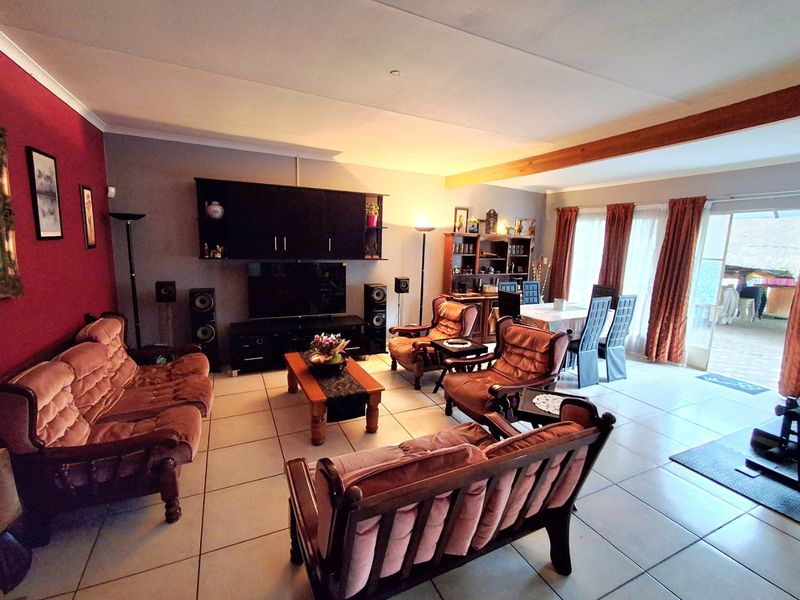 Spacious open-plan living and dining area featuring tiled flooring, built-in cabinetry, and direct access to the patio through sliding glass doors.