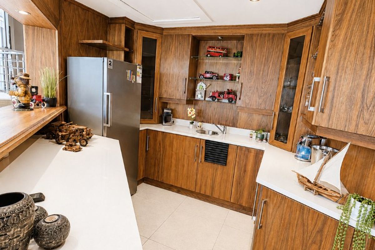 A well-maintained kitchen featuring warm wood cabinetry, stone countertops, and modern recessed lighting, offering a functional and classic aesthetic.